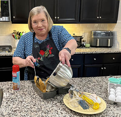 Chris Oxford demonstrates a baking recipe in her home kitchen classroom.