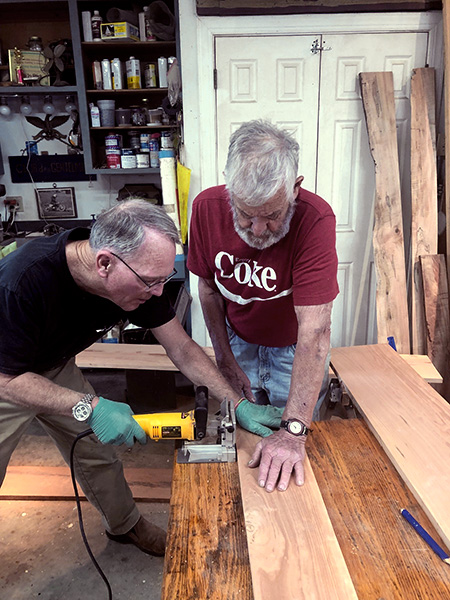 Retirees Dick Doyle and Gordon Burgess work together to build furniture from storm-fallen trees.